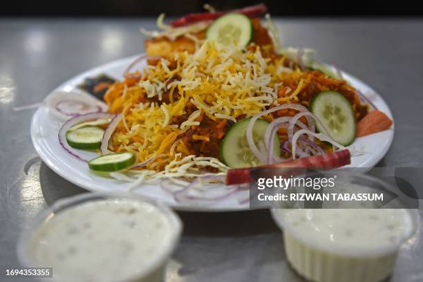 In this photograph taken on September 19 a plate of biryani is kept for customers at a restaurant in Karachi. Eying each other across a stream of...