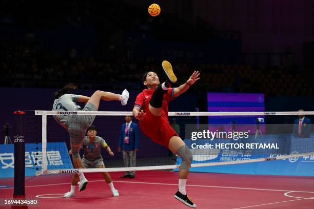 Thailand's Wassana Soiraya kicks the ball as Laos's Koy Xayavong defends in the semifinal of the women's team sepak takraw match during the Hangzhou...