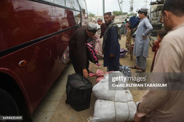 In this photo taken on September 21 Afghans prepare to board a bus heading to Afghanistan from Karachi. Afghans have poured into Pakistan in their...