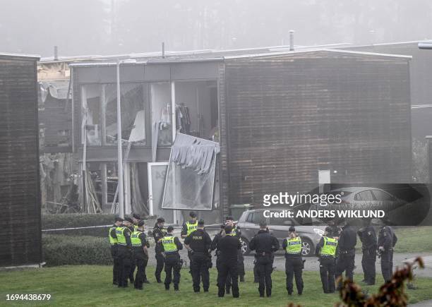 Policemen stand in front of a damaged building after a powerful explosion occurred in the early morning of September 28, 2023 in a housing area in...