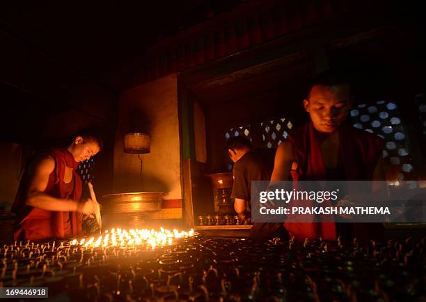 Nepalese monk lights a butter lamp during the Buddhist festival locally called "Saka Dawa" at Swayambhunath in Kathmandu on May 24 one day ahead of...