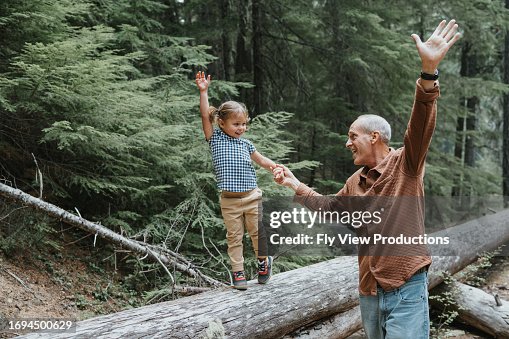 Joyful little girl enjoying nature with her playful grandfather