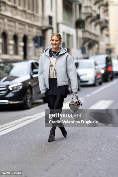 Emili Sindlev is seen wearing Nike silver earrings, a Chanel pearl necklace, a grey oversized Miu Miu hoodie, a Max Mara oversized printed t-shirt, a...