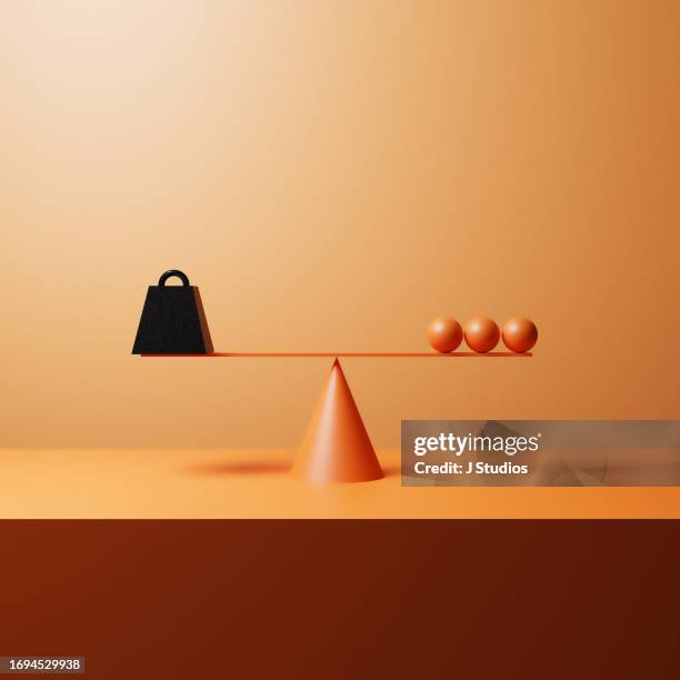 metal weight and three orange spheres - side by side comparison stock pictures, royalty-free photos & images