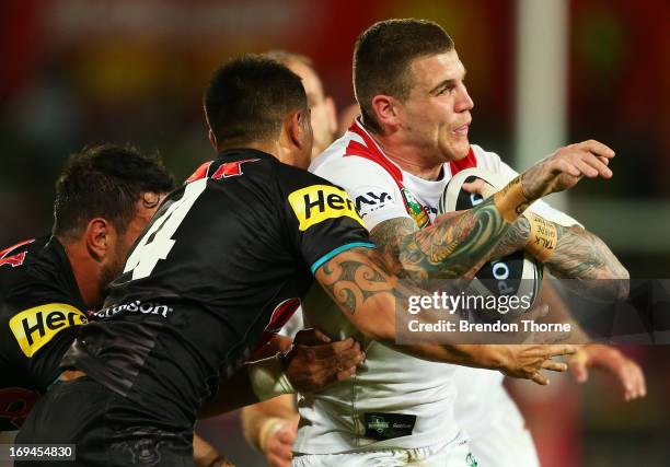 Josh Dugan of the Dragons is tackled by the Panthers defence during the round 11 NRL match between the St George Ilawarra Dragons and the Penrith...