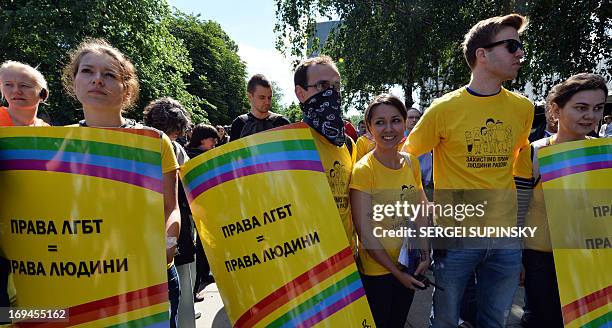 Activists carry placards reading "LGB rights are human rights" during the Gay Parade in Kiev on May 25, 2013. Around a hundred gay rights activists...