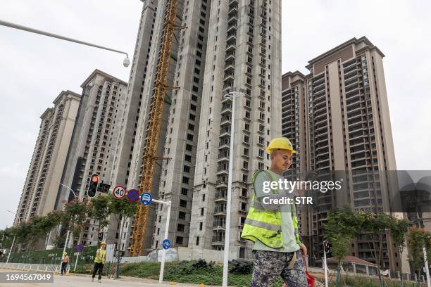 Worker walks past a housing complex under construction by Chinese property developer Evergrande in Wuhan, in China's central Hubei province on...
