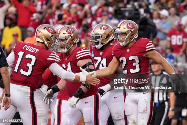 Christian McCaffrey of the San Francisco 49ers celebrates with Brock Purdy after scoring a touchdown against the New York Giants during the second...
