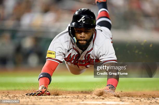 Michael Harris II of the Atlanta Braves slides into home plate and scores in the fifth inning against the Washington Nationals at Nationals Park on...