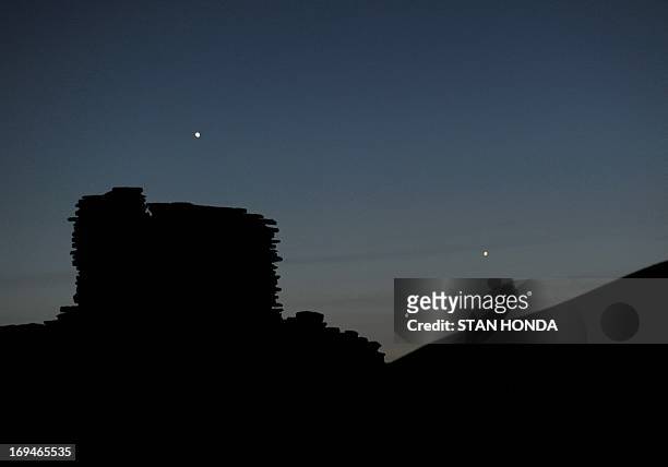 The planets Jupiter , Venus and Mercury are seen in an unusual conjunction setting over the Wupatki pueblo ruin on May 24, 2013 at Wupatki National...