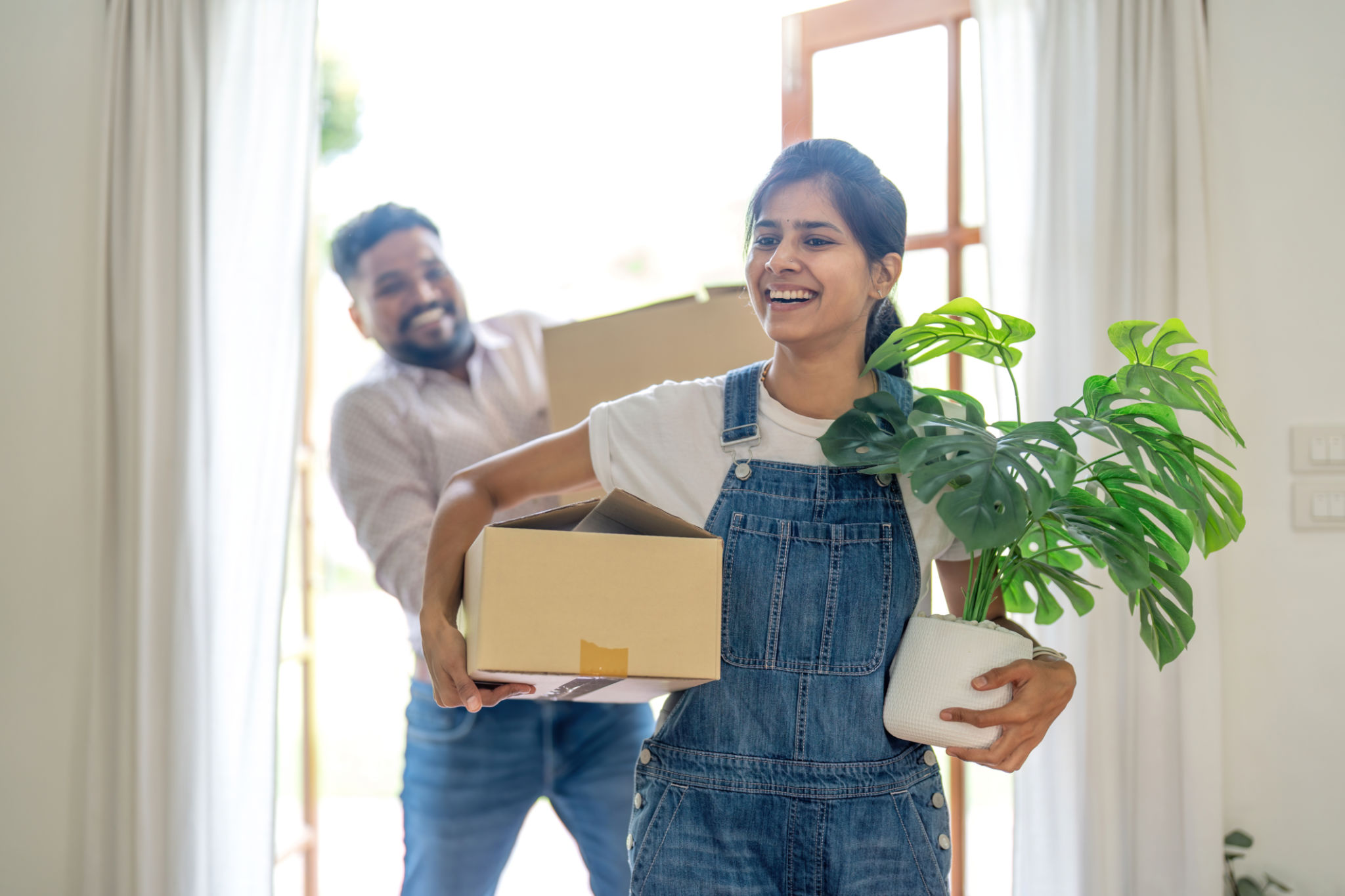 Indian young couple move the box into the home at new home. Relocation, moving to new home concept Indian young couple move the box into the home at new home. Relocation, moving to new home concept