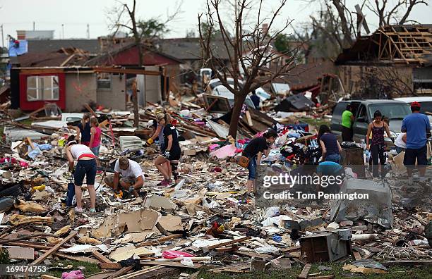 Volunteers help homeowners dig through a tornado ravaged neighborhood on May 25, 2013 in Moore, Oklahoma. The tornado of EF5 strength and two miles...