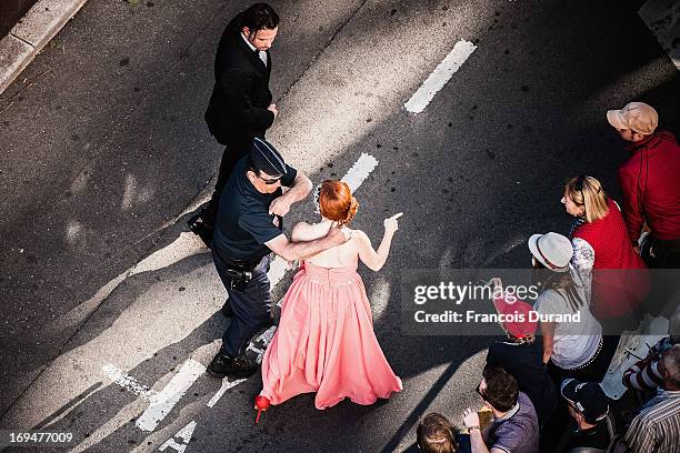 Phoebe Price is approached by a police officer as she arrives at 'La Venus A La Fourrure' premiere during The 66th Annual Cannes Film Festival on May...