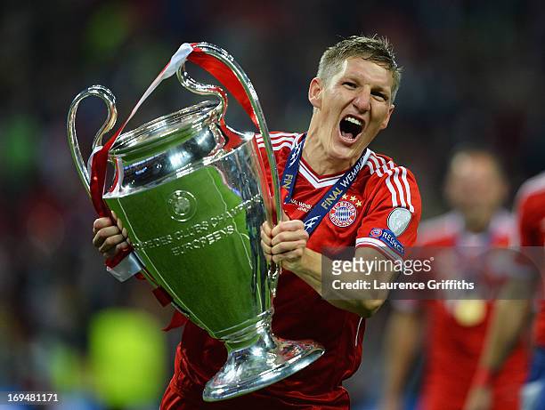 Bastian Schweinsteiger of Bayern Muenchen holds the trophy after winning the UEFA Champions League final match against Borussia Dortmund at Wembley...