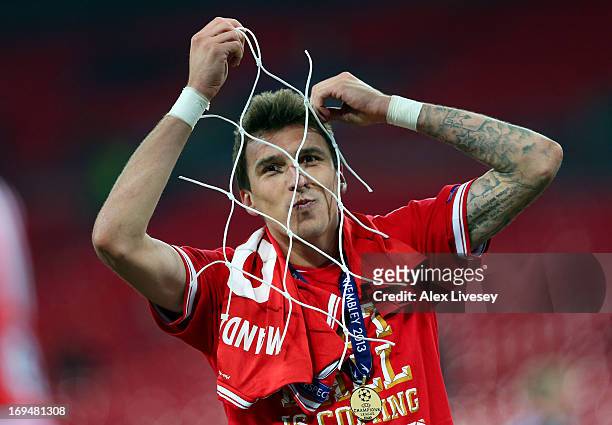 Mario Mandzukic of Bayern Muenchen celebrates with a piece of goal netting after winning the UEFA Champions League final match against Borussia...