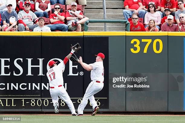 Shin-Soo Choo and Jay Bruce of the Cincinnati Reds collide as Choo makes a catch near the center field wall against the Chicago Cubs during the game...