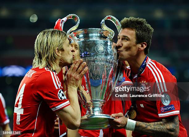 Anatoliy Tymoshchuk of Bayern Muenchen and team-mate Mario Mandzukic kiss the trophy after winning the UEFA Champions League final match against...