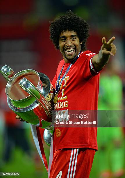 Dante of Bayern Muenchen holds the trophy after winning the UEFA Champions League final match against Borussia Dortmund at Wembley Stadium on May 25,...