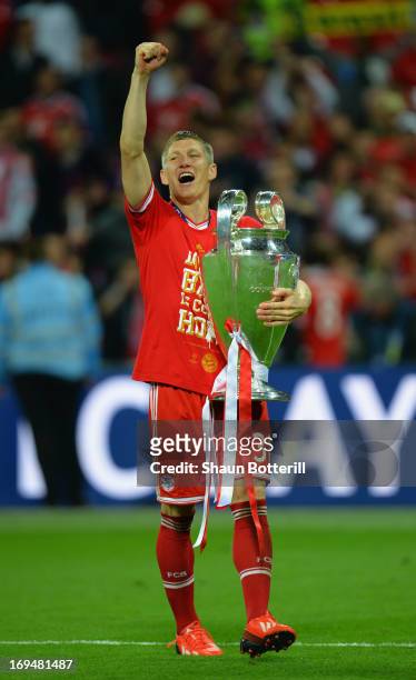 Bastian Schweinsteiger of Bayern Muenchen holds the trophy after winning the UEFA Champions League final match against Borussia Dortmund at Wembley...