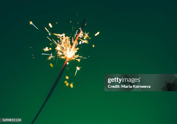 close-up of a sparkler on green background. - bengalischer feuer stock-fotos und bilder