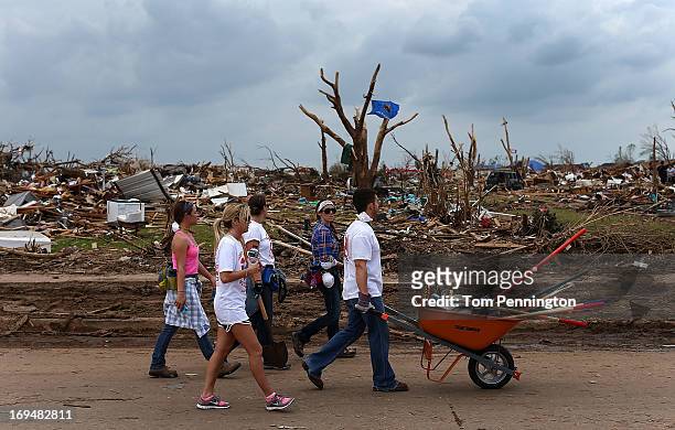 Group of volunteers from Texas make their way through a tornado ravaged neighborhood while helping residents clean up May 25, 2013 in Moore,...