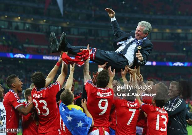 Head Coach Jupp Heynckes of Bayern Muenchen is thrown into the air by his players after winning the UEFA Champions League final match against...