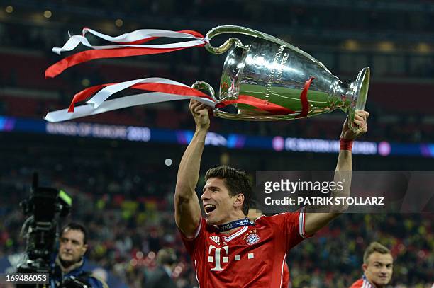 Bayern Munich's German striker Mario Gomez celebrates with the trophy on the pitch after their victory in the UEFA Champions League final football...