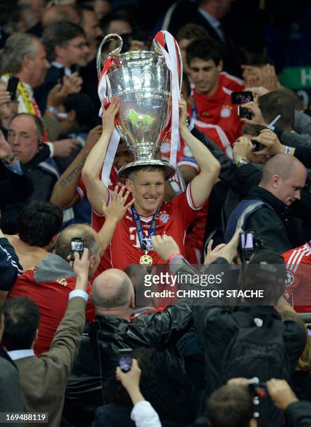 Bayern Munich's German midfielder Bastian Schweinsteiger celebrates with the trophy on his head after winning the UEFA Champions League final...