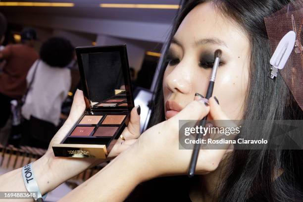 Make up artist and model backstage ahead of the Tom Ford fashion show during the Milan Fashion Week Womenswear Spring/Summer 2024 on September 21,...