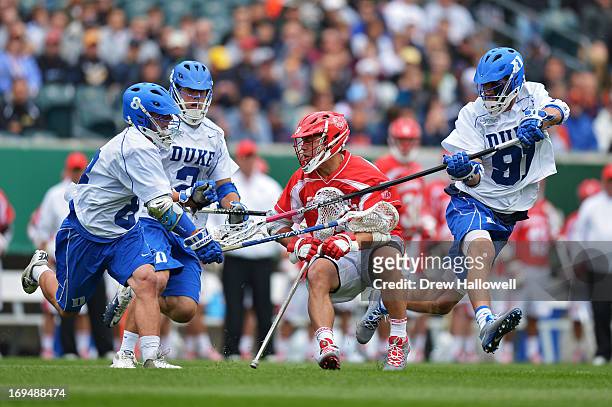 Rob Pannell of Cornell University Big Red tries to avoid Josh Dionne, David Lawson and Luke Duprey of the Duke University Blue Devils during a...