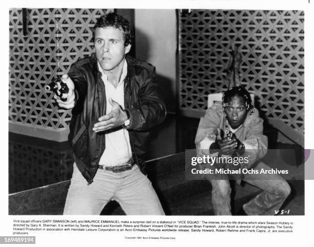 Gary Swanson and Maurice Emanuel point their guns in a scene from the film 'Vice Squad', 1982.