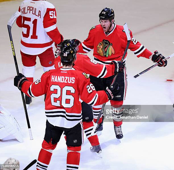 Bryan Bickell of the Chicago Blackhawks celebtrates his first period goal with Patrick Kane and Michal Handzus against the Detroit Red Wings in Game...