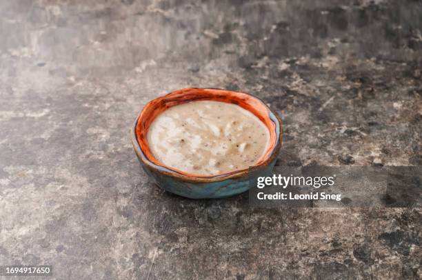 creamy garlic sauce on gray background - aioli stock-fotos und bilder