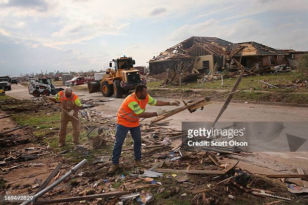 Workers from the Oklahoma Department of Transportation clear tornado debris that was piled along a street on May 25, 2013 in Moore, Oklahoma. A...