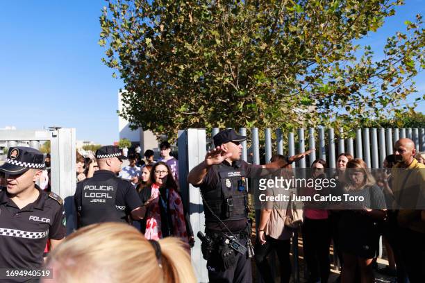 Police officer talks to people gathered outside a school where a stabbing incident took place earlier on September 28, 2023 in Jerez de la Frontera,...