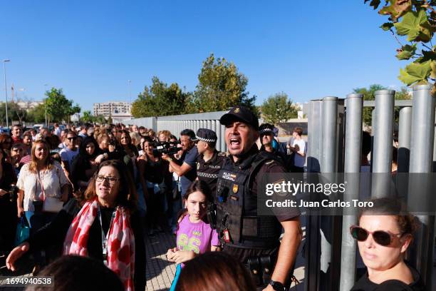 Police officer addresses a crowd gathered outside a school where a stabbing incident took place earlier on September 28, 2023 in Jerez de la...