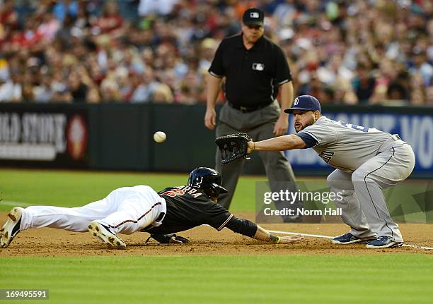 Yonder Alonso of the San Diego Padres catches a throw from the pitcher as Gerardo Parra of the Arizona Diamondbacks dives into first base at Chase...