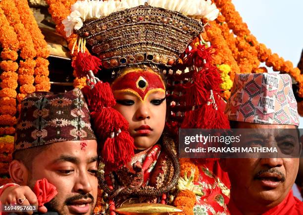 Girl revered as living goddess 'Kumari' is carried by devotees during a procession on the occasion of 'Indra Jatra' festival in Kathmandu on...