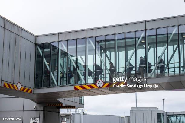 passengers embarking on a plane through a passenger boarding bridge at dublin airport - passenger boarding bridge stock pictures, royalty-free photos & images
