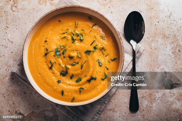 pumpkin soup on brown background - cris cantón photography stock-fotos und bilder