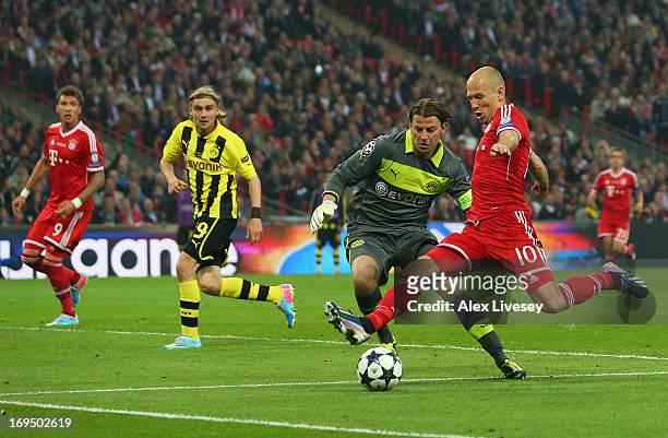 Arjen Robben of Bayern Muenchen beats goalkeeper Roman Weidenfeller of Borussia Dortmund to cross for Mario Mandzukic of Bayern Muenchen to score...