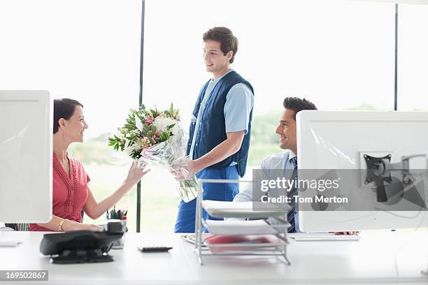 deliveryman delivering flowers to businesswoman in office - colleague appreciation stock pictures, royalty-free photos & images