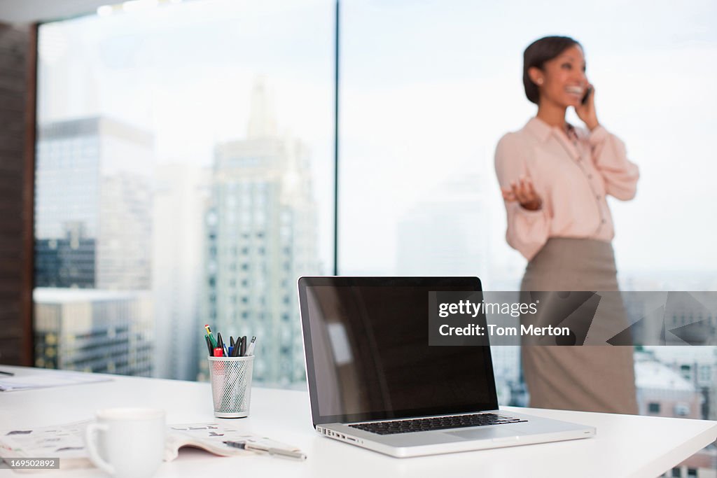 Businesswoman talking on cell phone in office