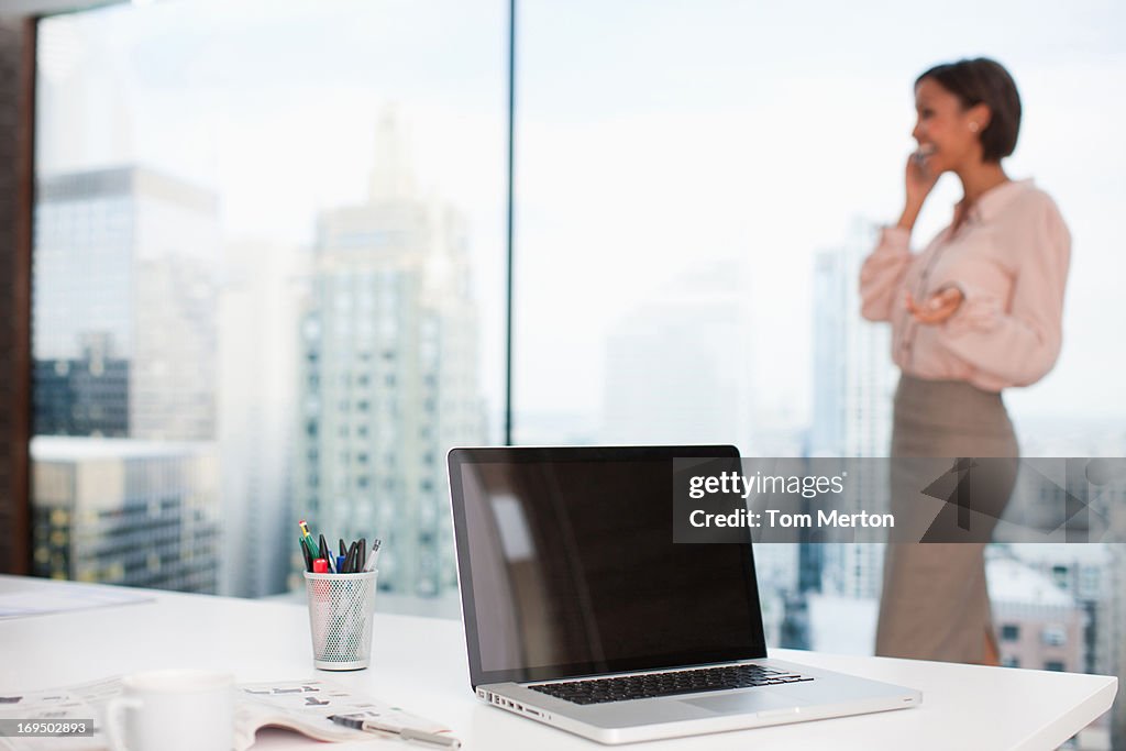 Businesswoman talking on cell phone in office