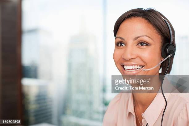 smiling businesswoman in headset - answering stock pictures, royalty-free photos & images