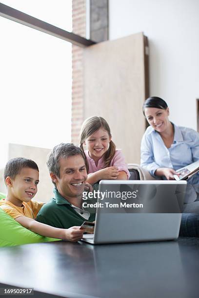 famiglia utilizzando il computer portatile insieme - mixed magazine foto e immagini stock