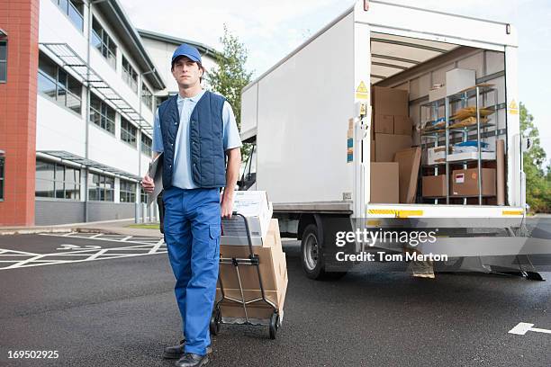 deliveryman puling boxen auf hand truck - sackkarre stock-fotos und bilder