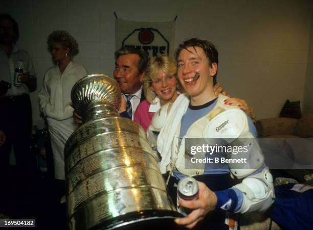 Jari Kurri of the Edmonton Oilers smokes a cigar and celebrates with the Stanley Cup Trophy in the locker room after the Oilers defeated the...