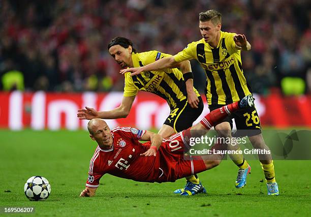 Arjen Robben of Bayern Muenchen battles with Neven Subotic and Lukasz Piszczek of Borussia Dortmund during the UEFA Champions League final match...