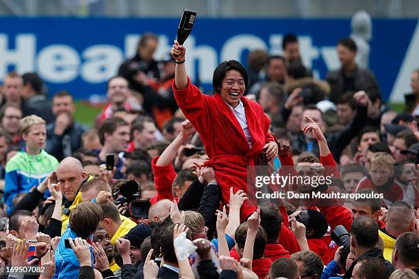 Yoshiaki Takagi of Utrecht celebrates with team mates as the fans cheer his name after winning the Eredivisie Europa League Play off match between FC...